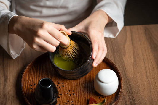 Ceremonial grade matcha being whisked in a traditional bowl with a bamboo chasen