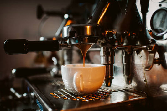 A perfect espresso shot with golden crema in a small ceramic cup — brewed at home with specialty coffee beans